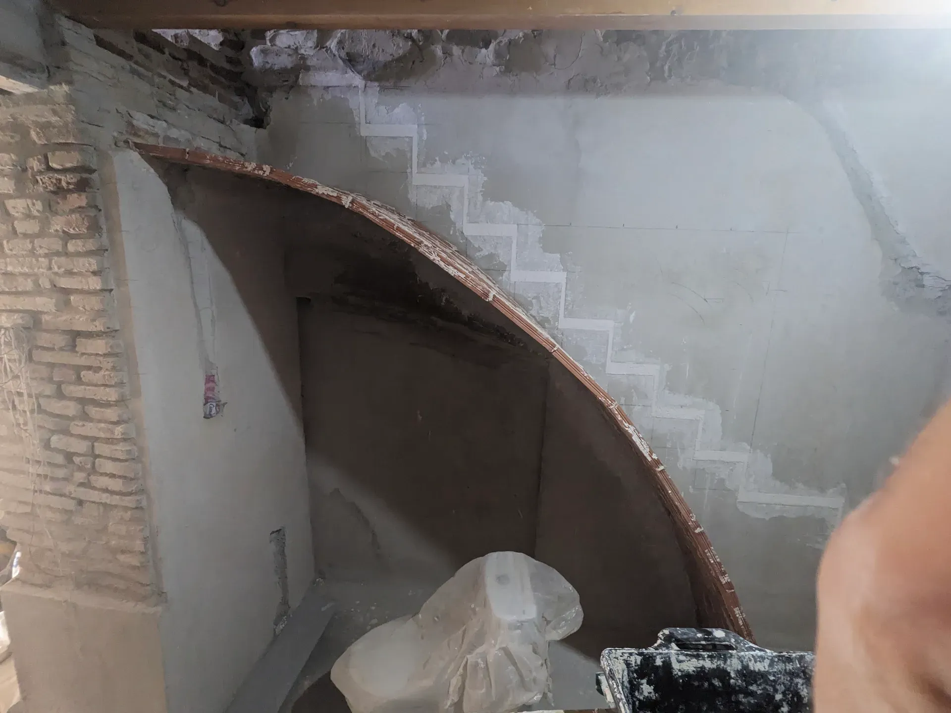 Vista inferior del arranque de la bóveda de ladrillo, siguiendo el trazado marcado en la pared soporte