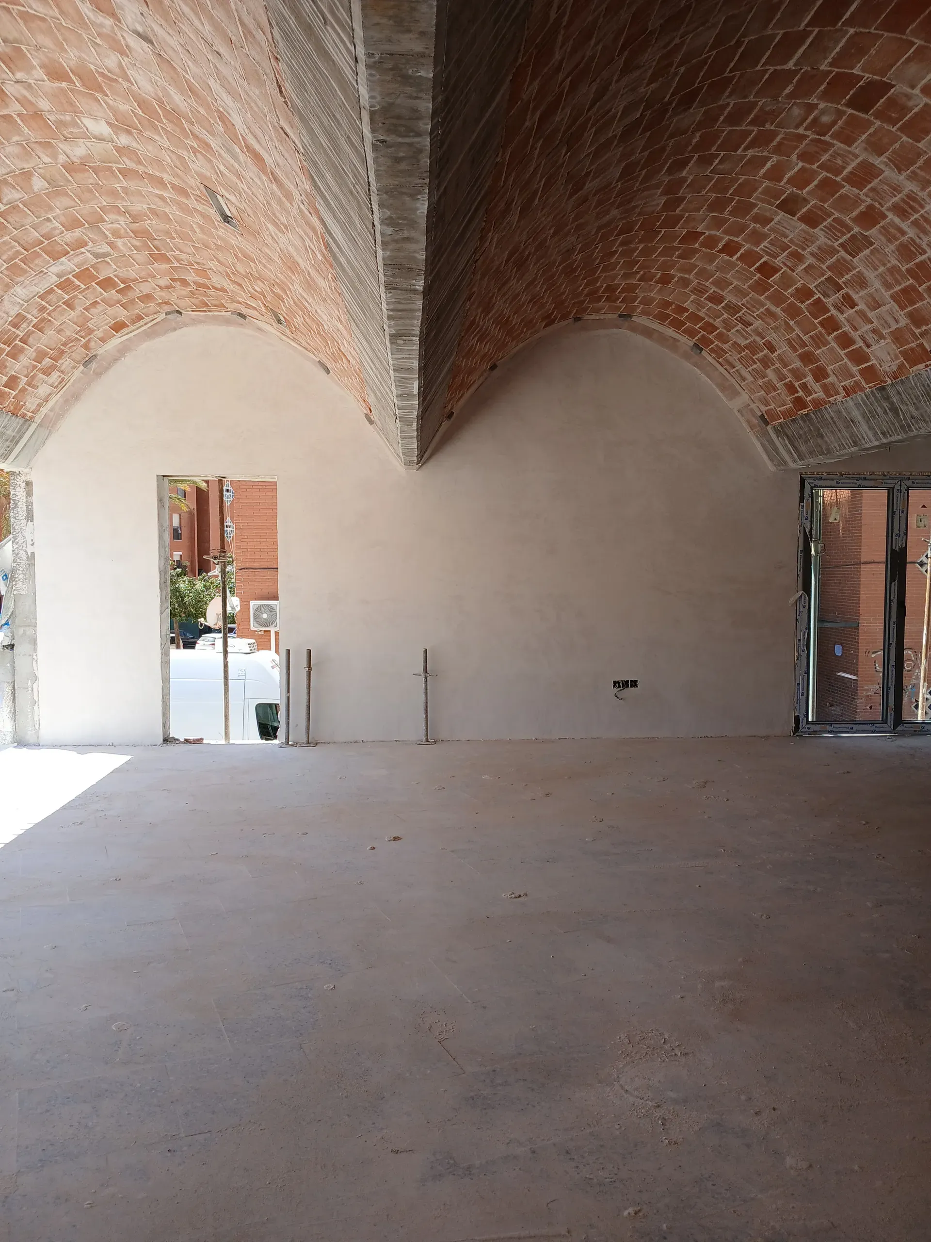 Arcos catenarios ejecutados con precisión, sosteniendo la rítmica disposición de los ladrillos superiores.