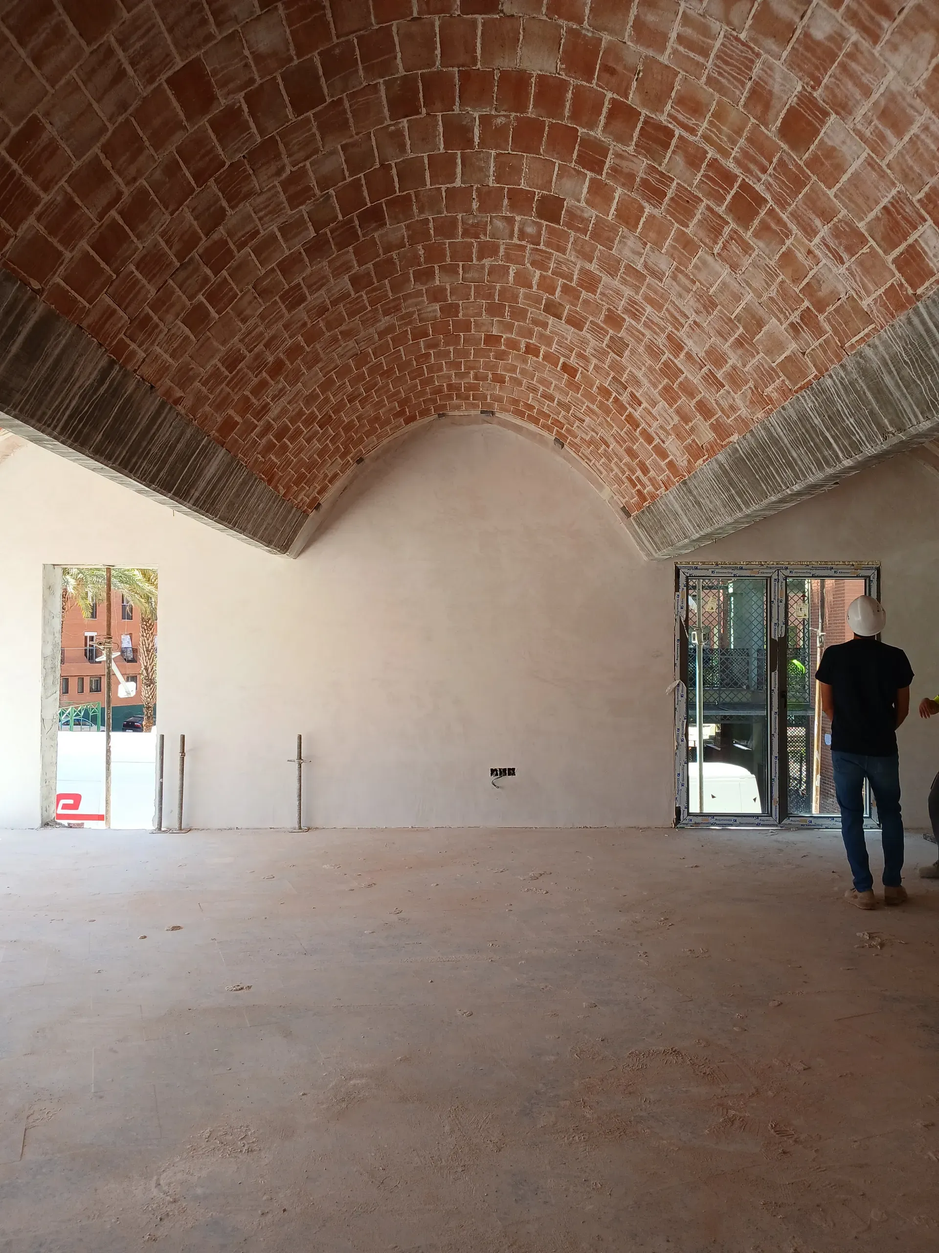Jesús observa el diálogo entre las superficies blancas y el restregón de ladrillos en el techo.