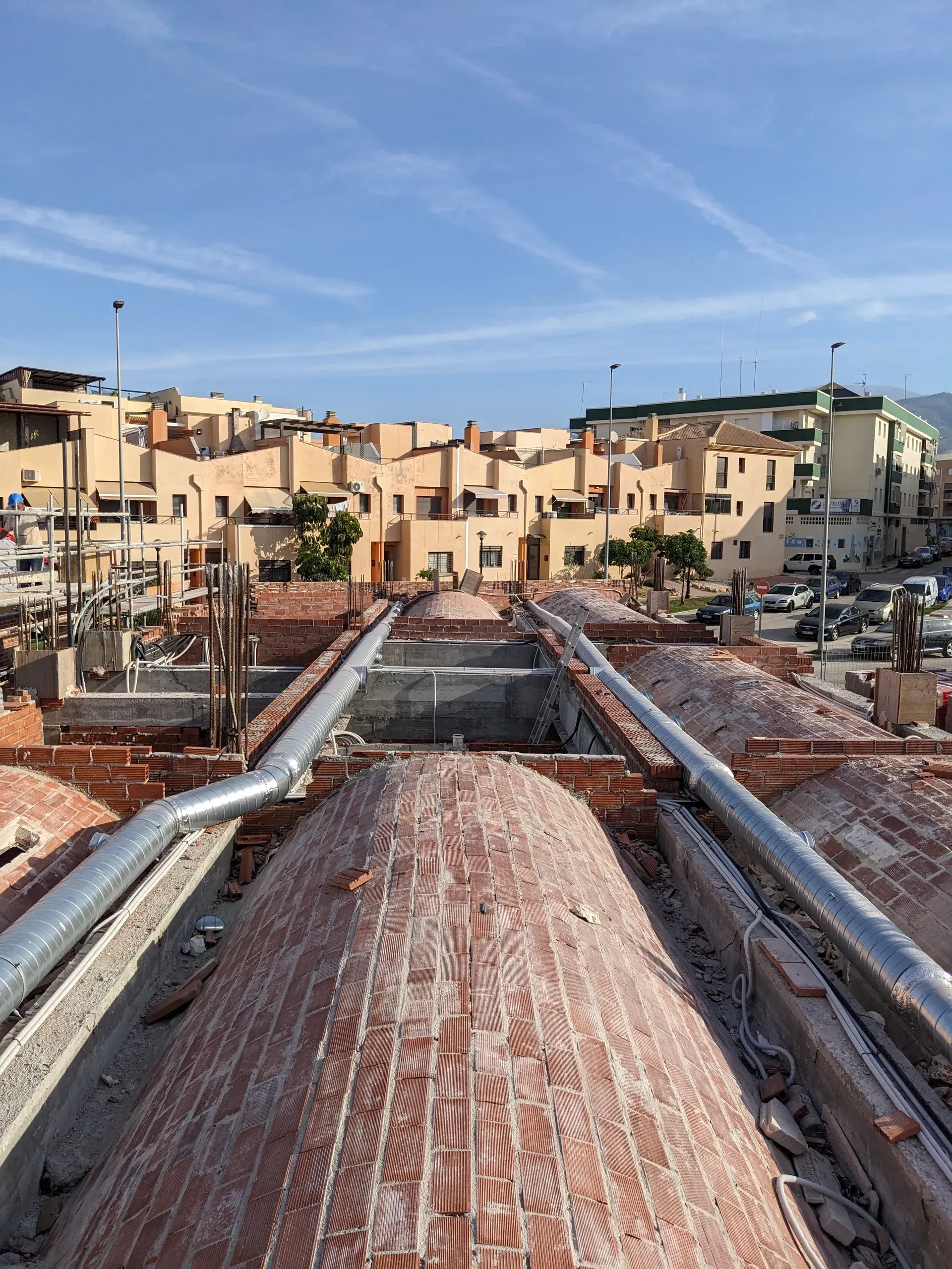 Confluencia de logística moderna y técnica vernácula con tuberías de ventilación sobre el extradós abovedado.