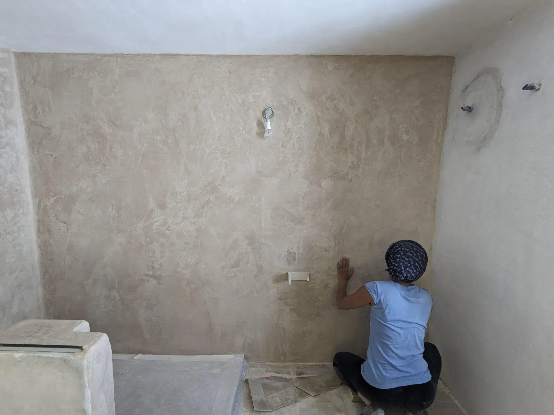 Proceso artesanal de aplicación de tadelakt en paramento vertical, buscando la planimetría perfecta