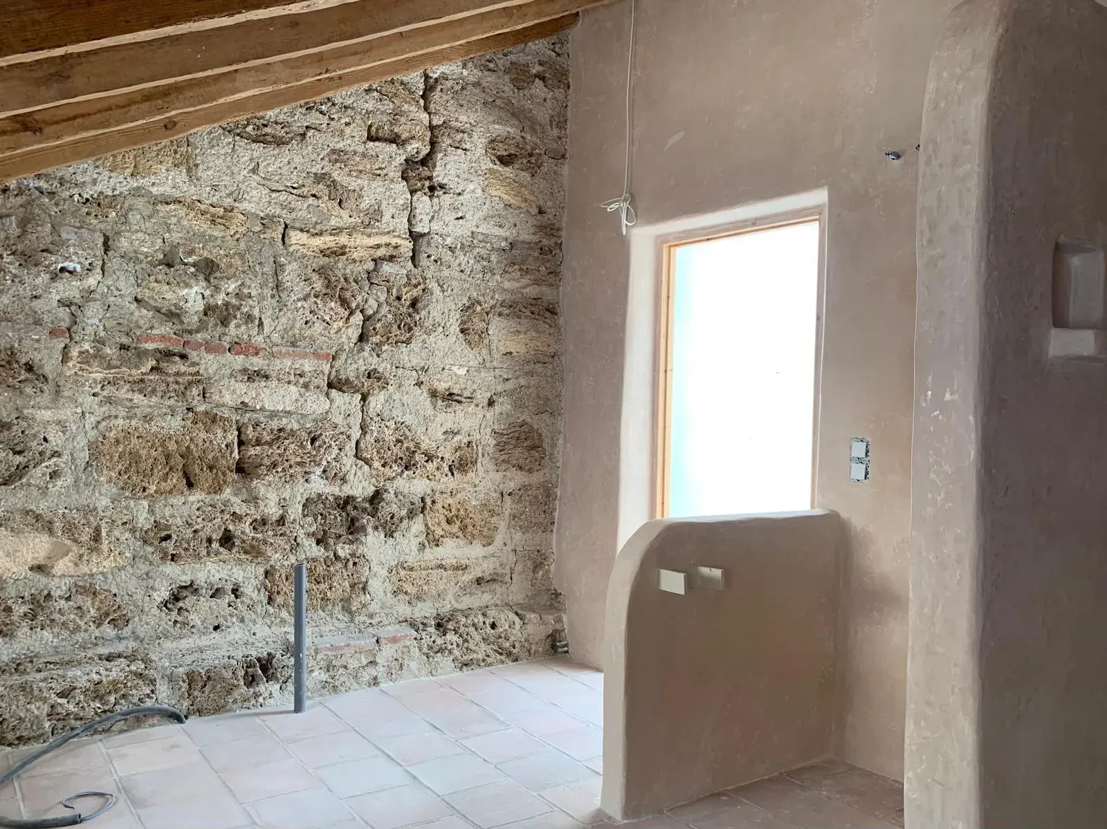 Diálogo entre la mampostería histórica y la suavidad del tadelakt iluminado por luz natural