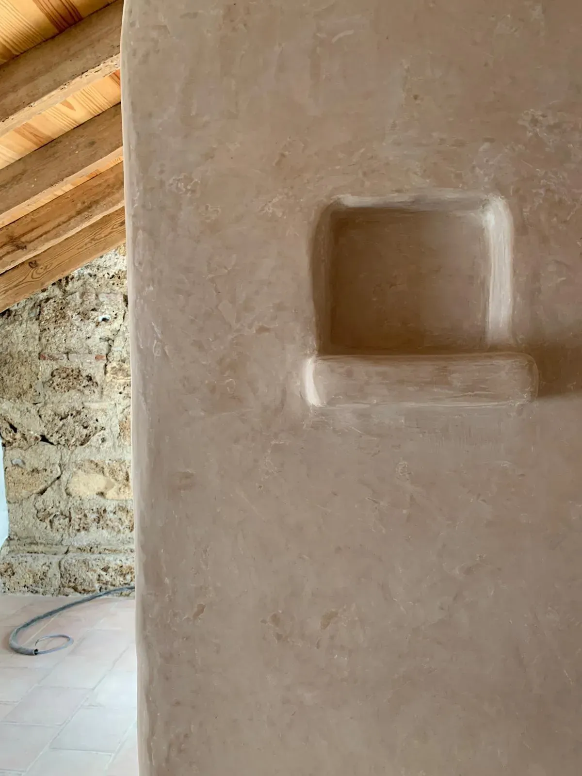 Hornacina esculpida en tadelakt junto a la piedra desnuda, un encuentro de texturas atemporales