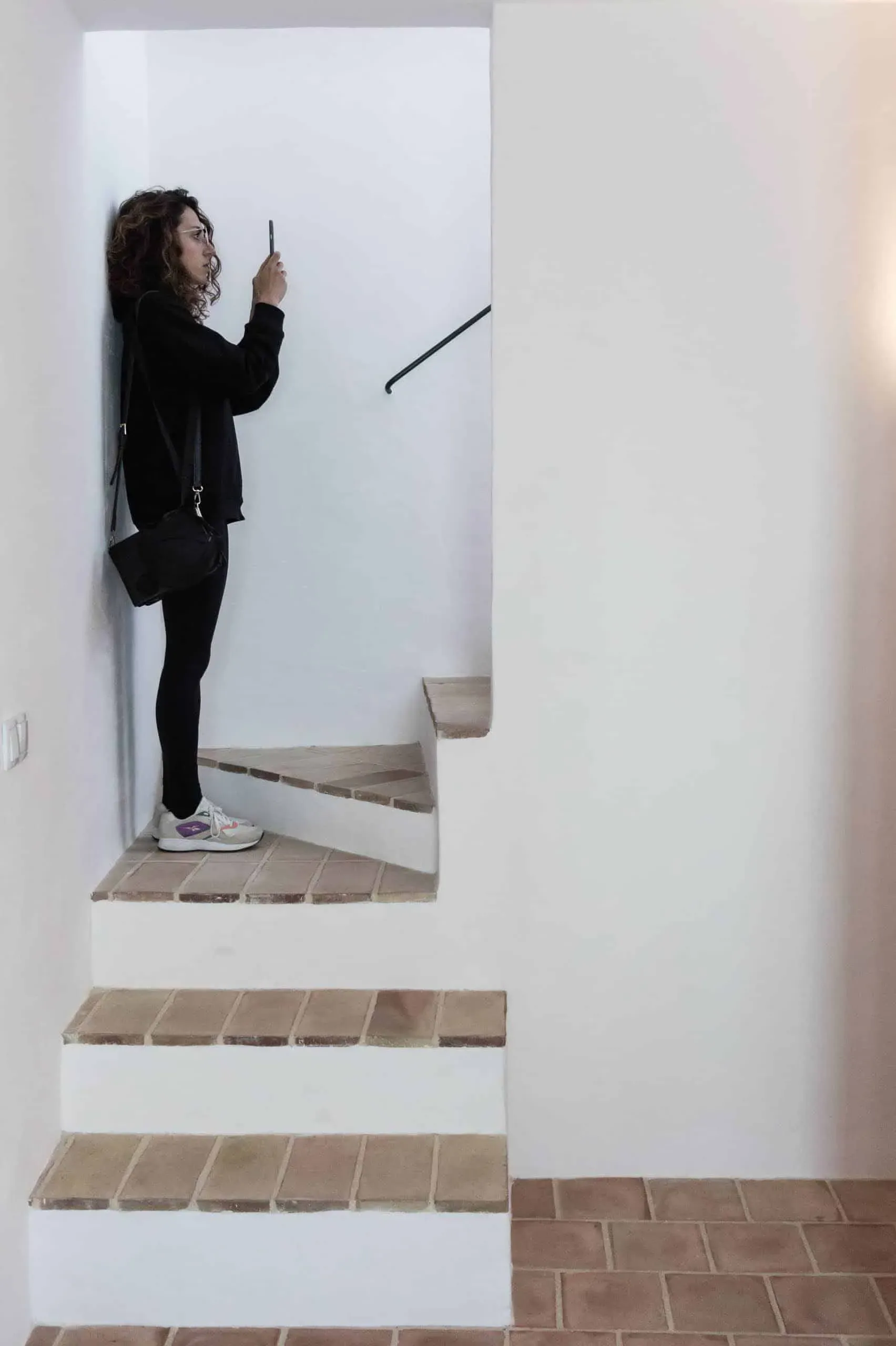 Minimalist white staircase with fired clay steps, contrast between modernity and tradition