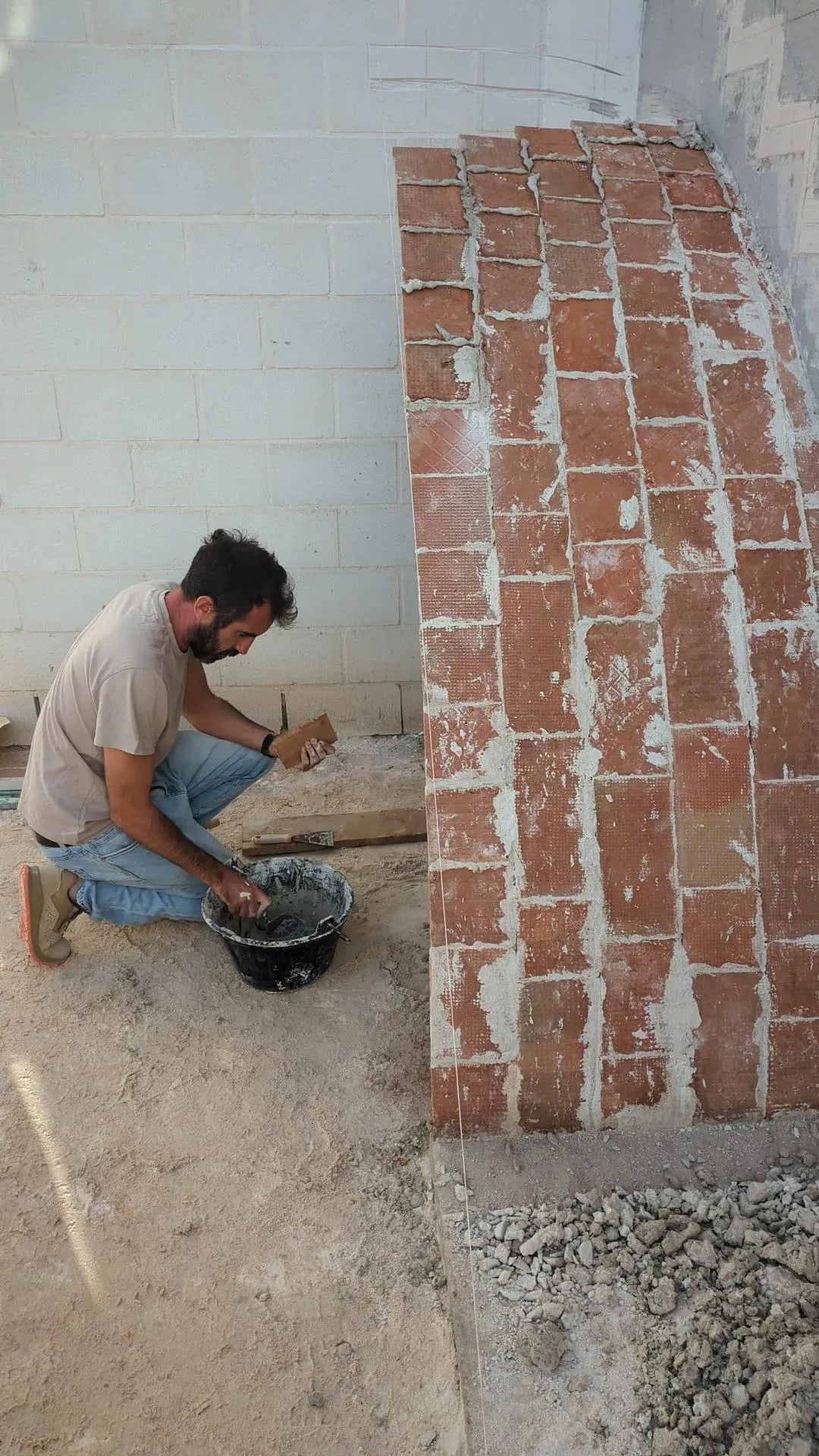 Jesús colocando los primeros ladrillos de la bóveda, suspendidos en el equilibrio del yeso