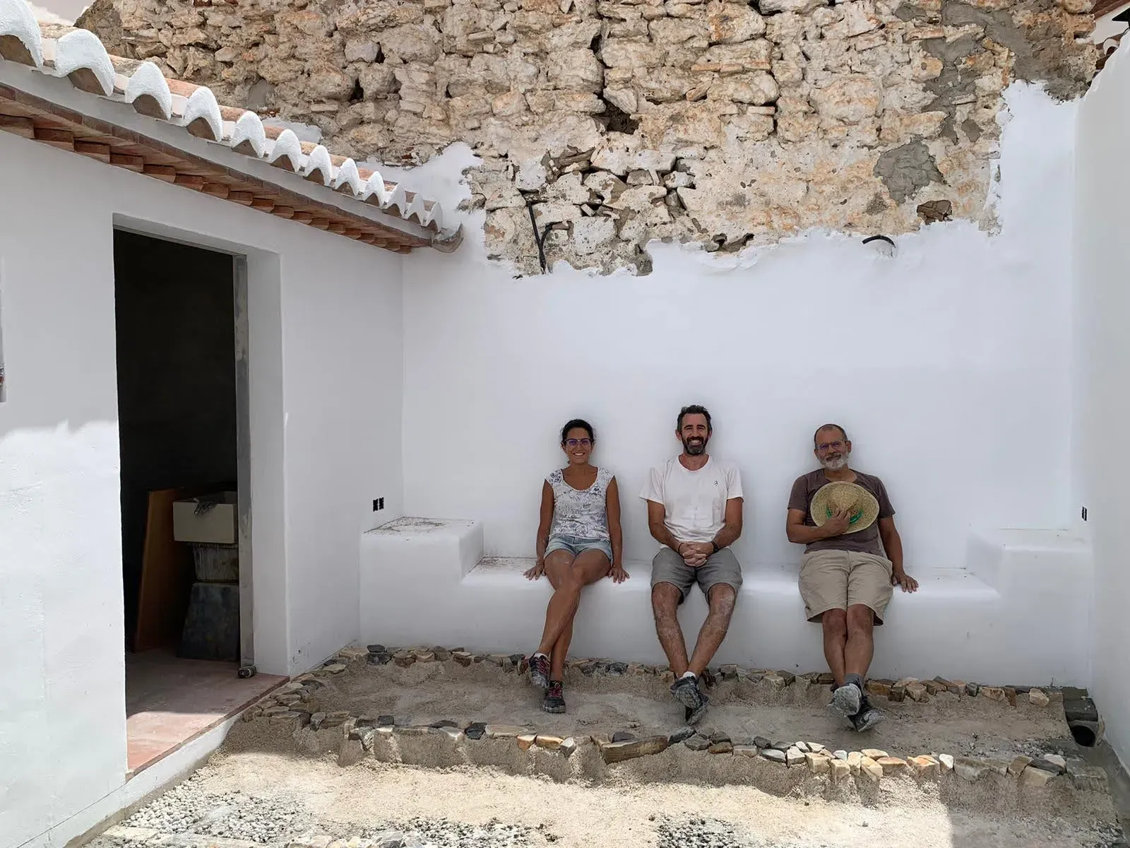 María José, Jesús y Javi descansando en el banco del patio tras la jornada de trabajo