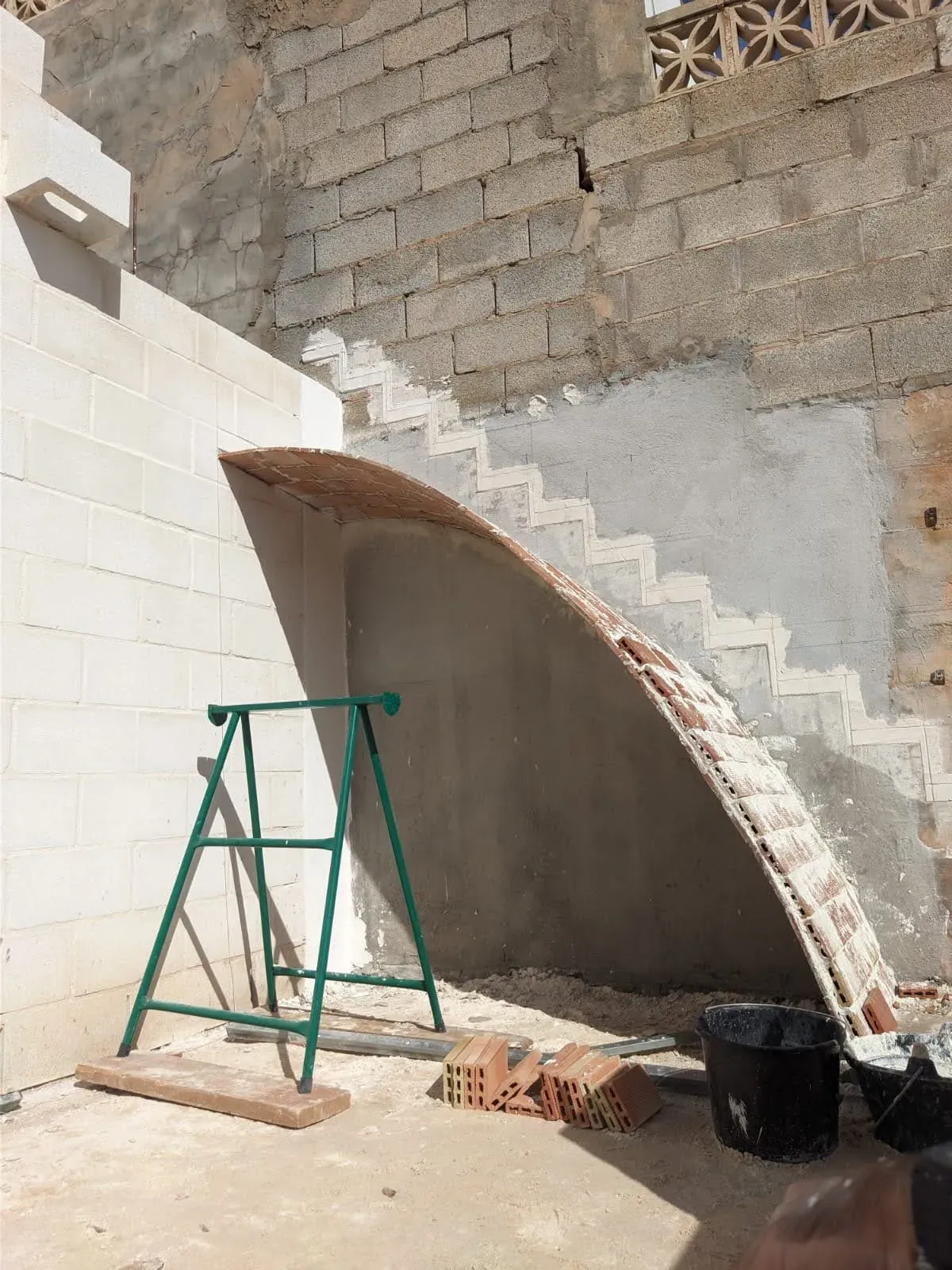 Inicio de la curvatura de la bóveda tabicada, arrancando desde el muro de bloques hacia el vacío