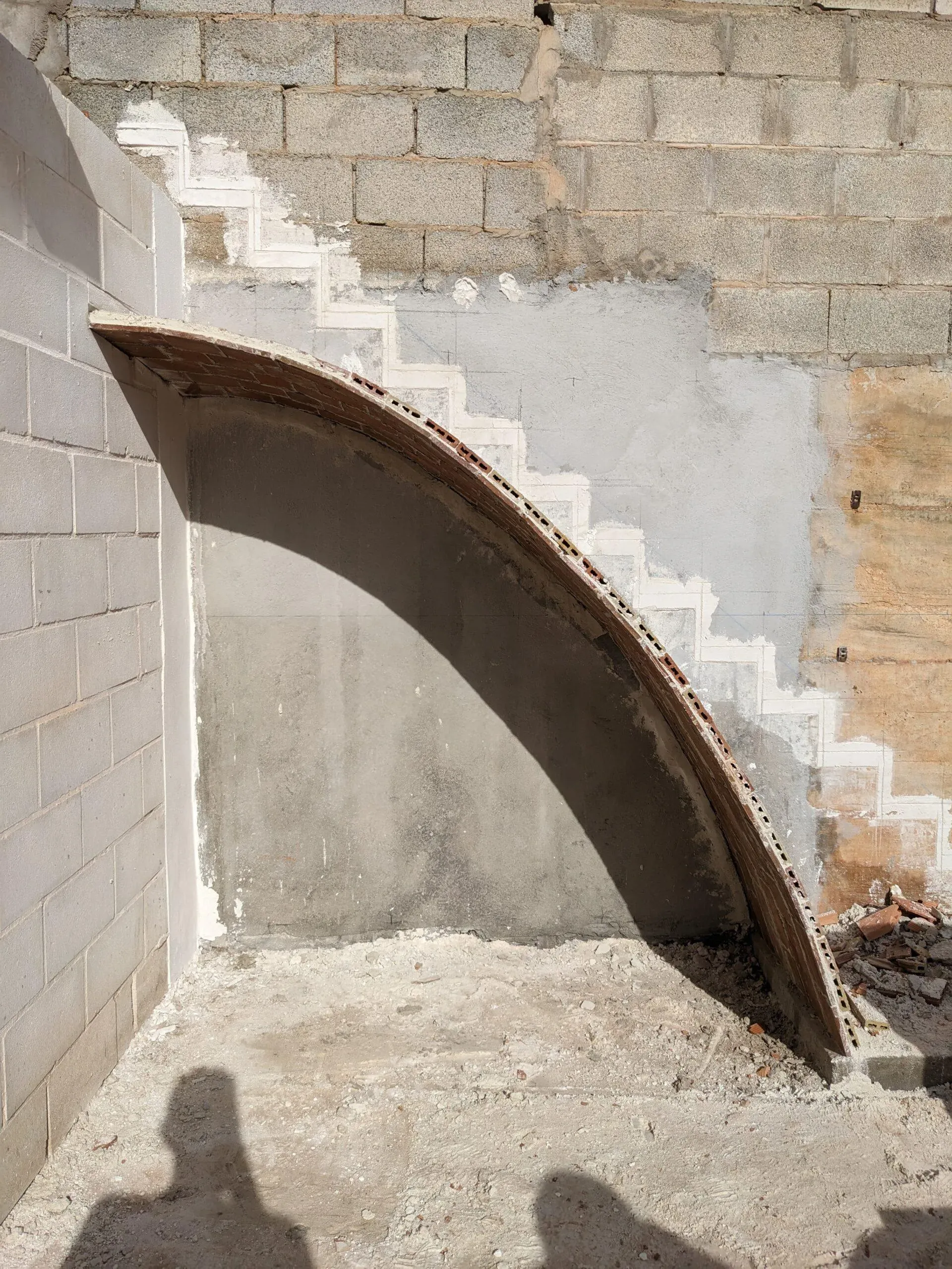Vista lateral del arco catenario en construcción, definiendo la silueta ligera de la escalera