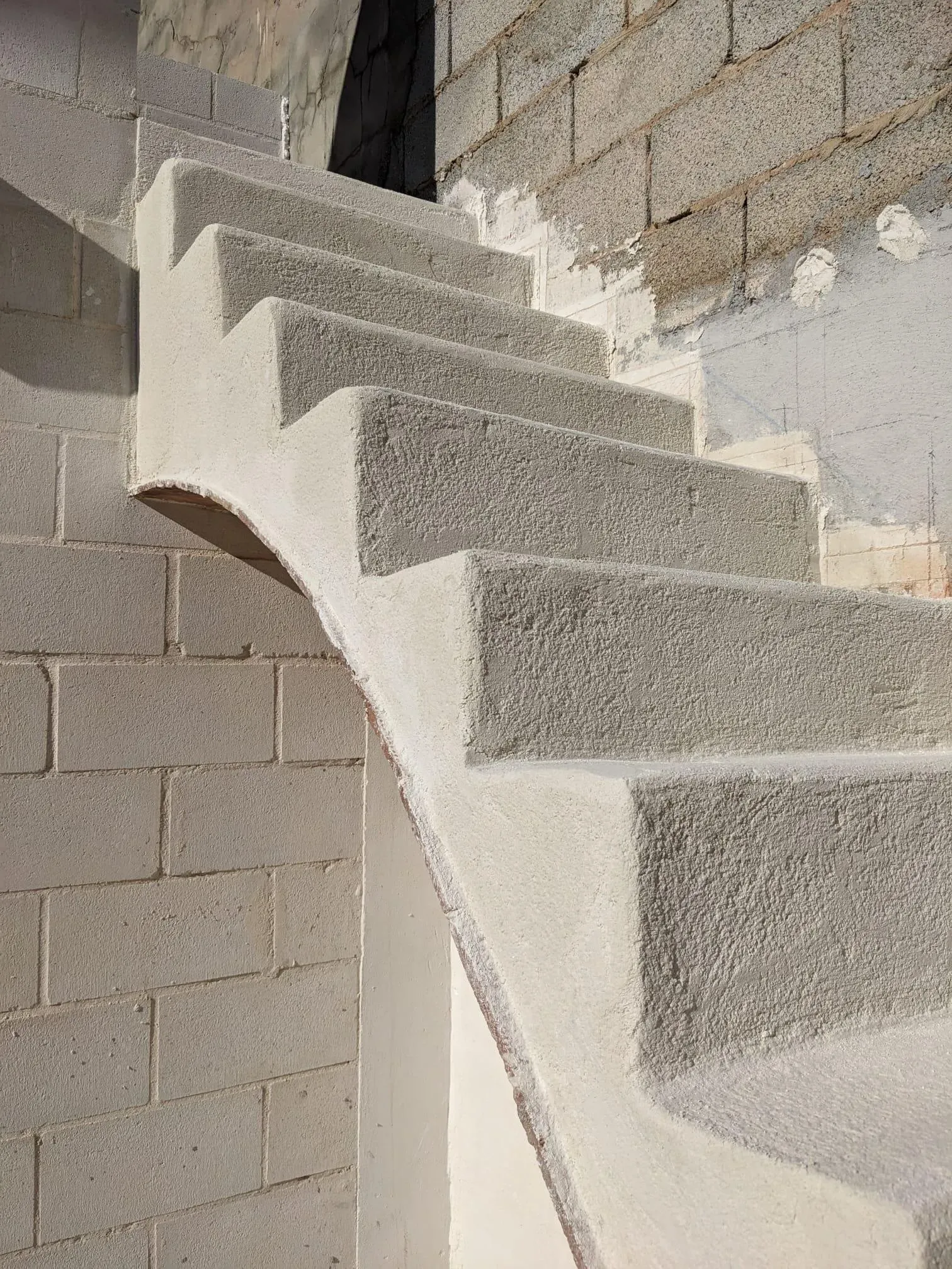 Aplicación de la capa base de revoco sobre los peldaños, preparando la superficie para el acabado final