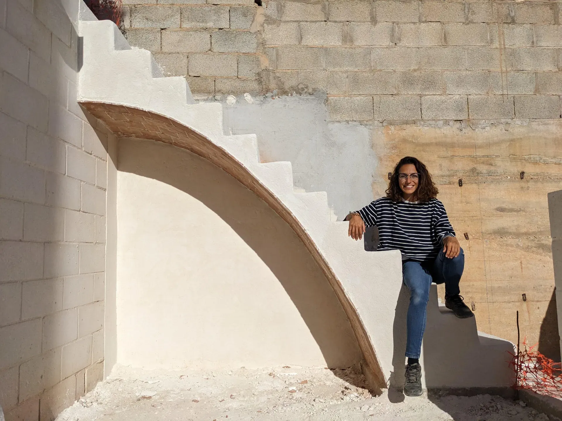 Acabado final de la escalera, donde la luz resalta las formas curvas y la continuidad del material