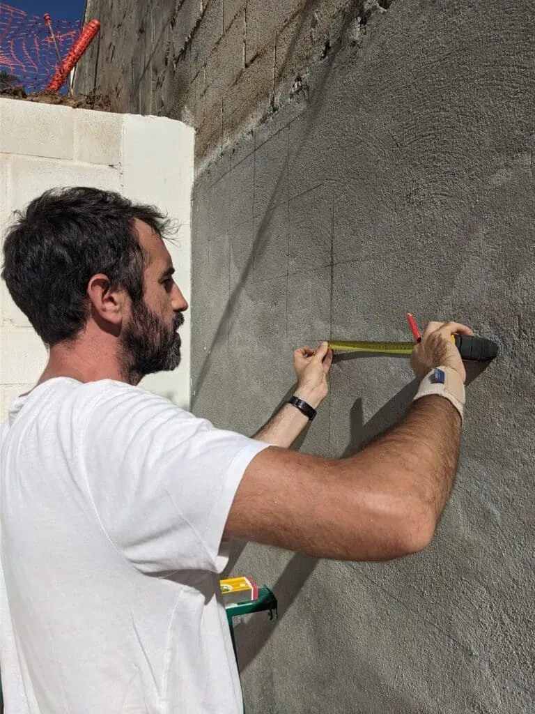 Jesús realizando mediciones sobre el muro para el replanteo del arco, inicio de la geometría precisa
