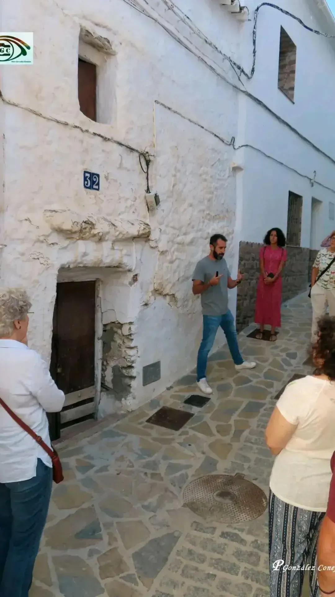 Charla técnica: Jesús describe la materialidad de una fachada con rastro de cal frente a un grupo