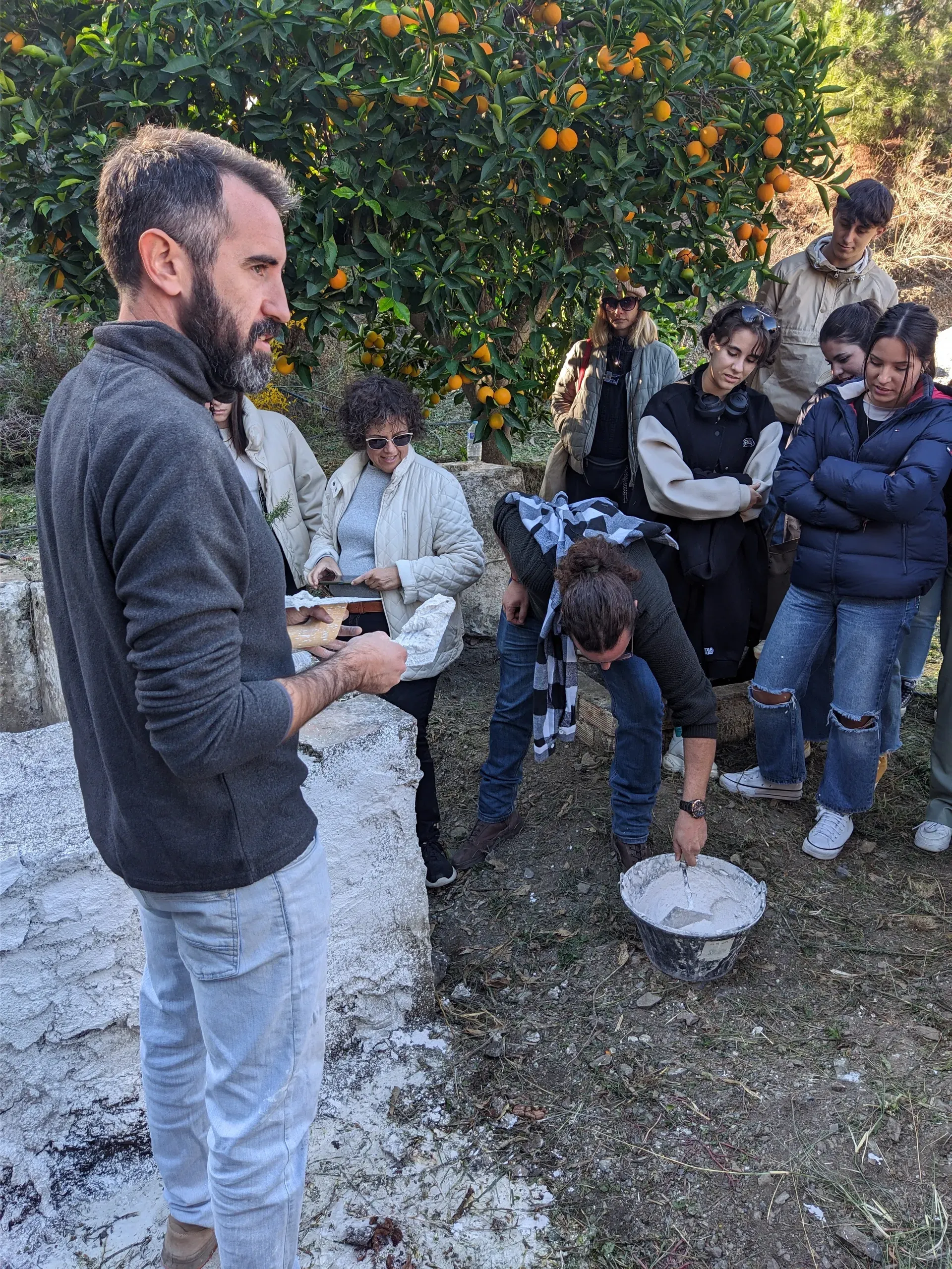Práctica de aplicación: Jesús supervisa a un alumno que maneja la llana con cal en pasta