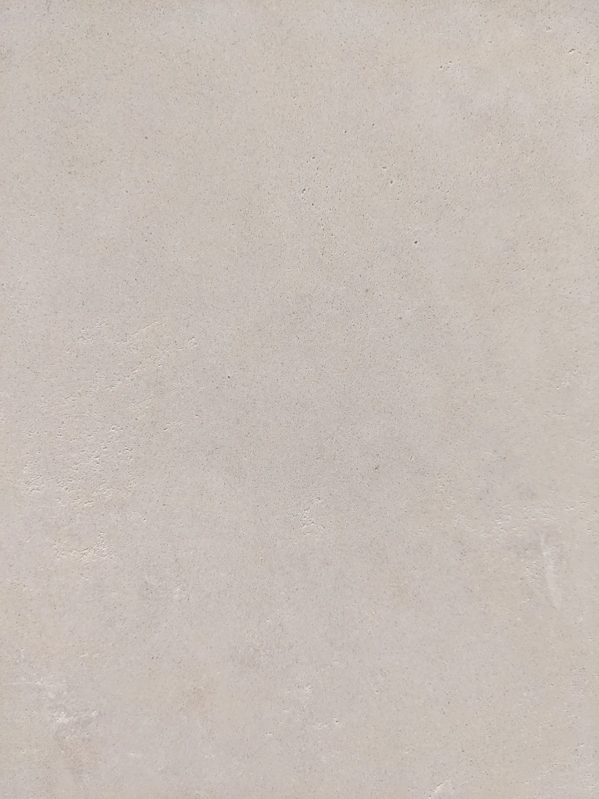 Detalle técnico de textura de mortero de cal manual con acabado mineral y grano fino