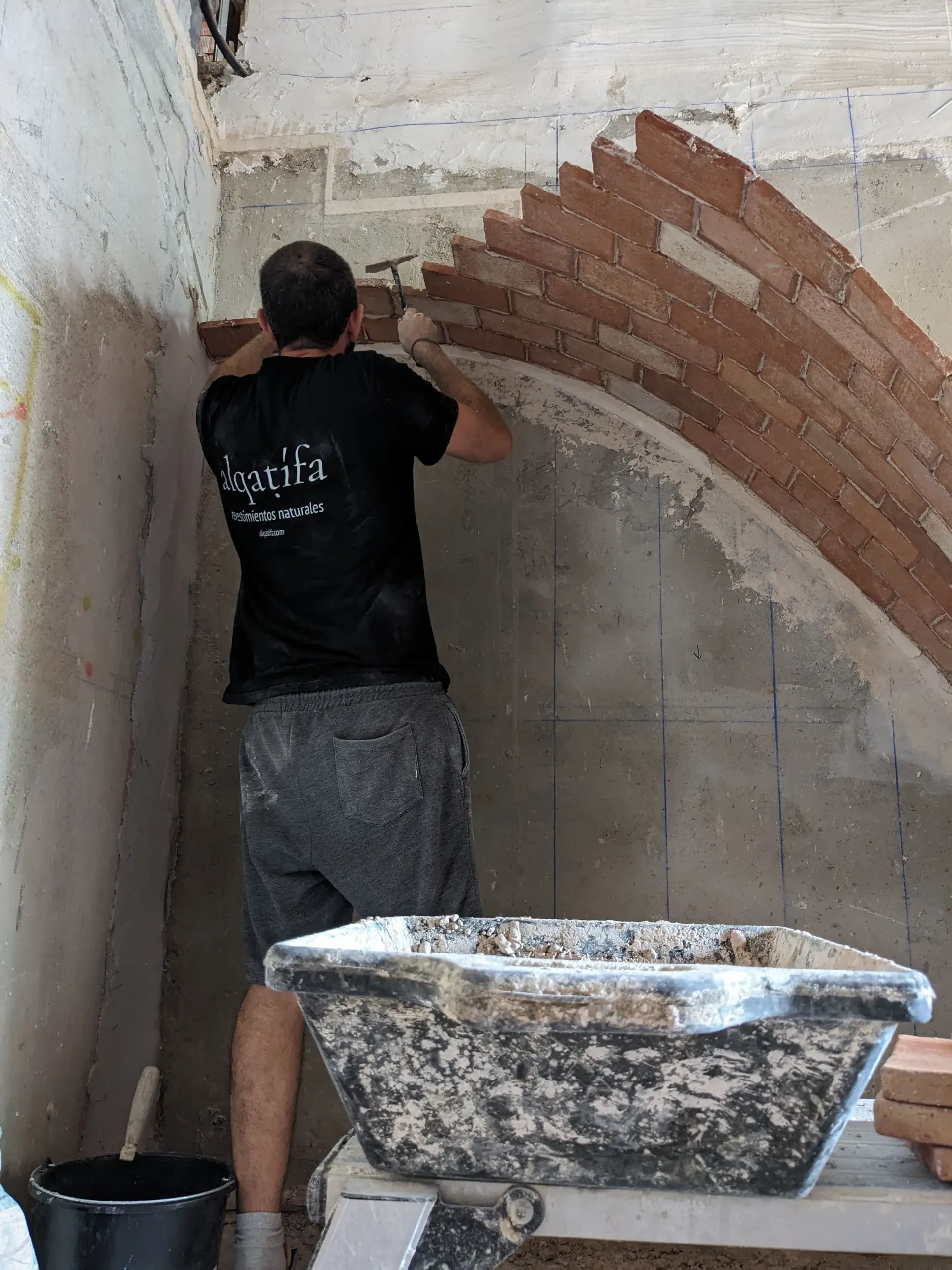 Artesano ejecutando la primera rosca de la bóveda con ladrillo y yeso