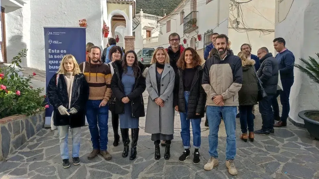 Foto de grupo de algunos participantes del programa Metapueblos junto a banner institucional