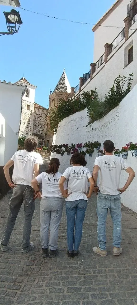 Vista posterior del equipo de Alqatifa observando el campanario de un pueblo blanco