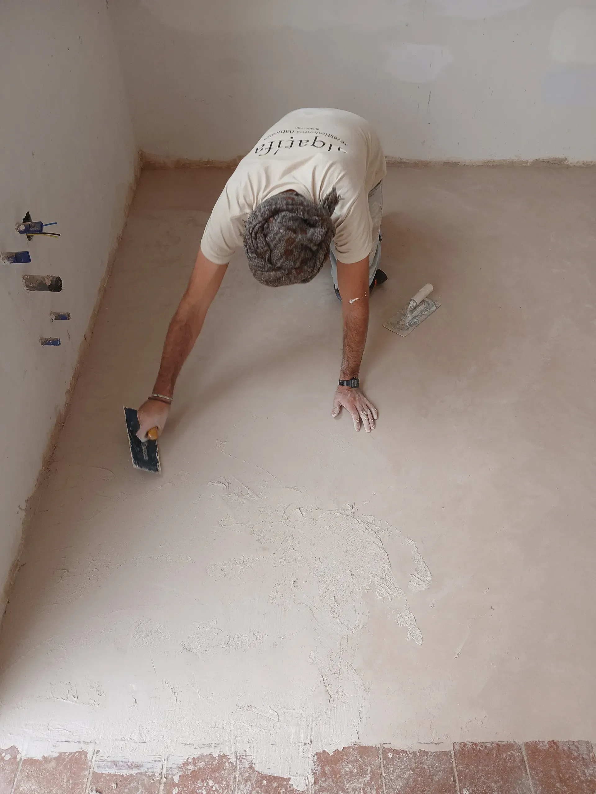 Artesano posando con herramientas tras la ejecución del pavimento continuo