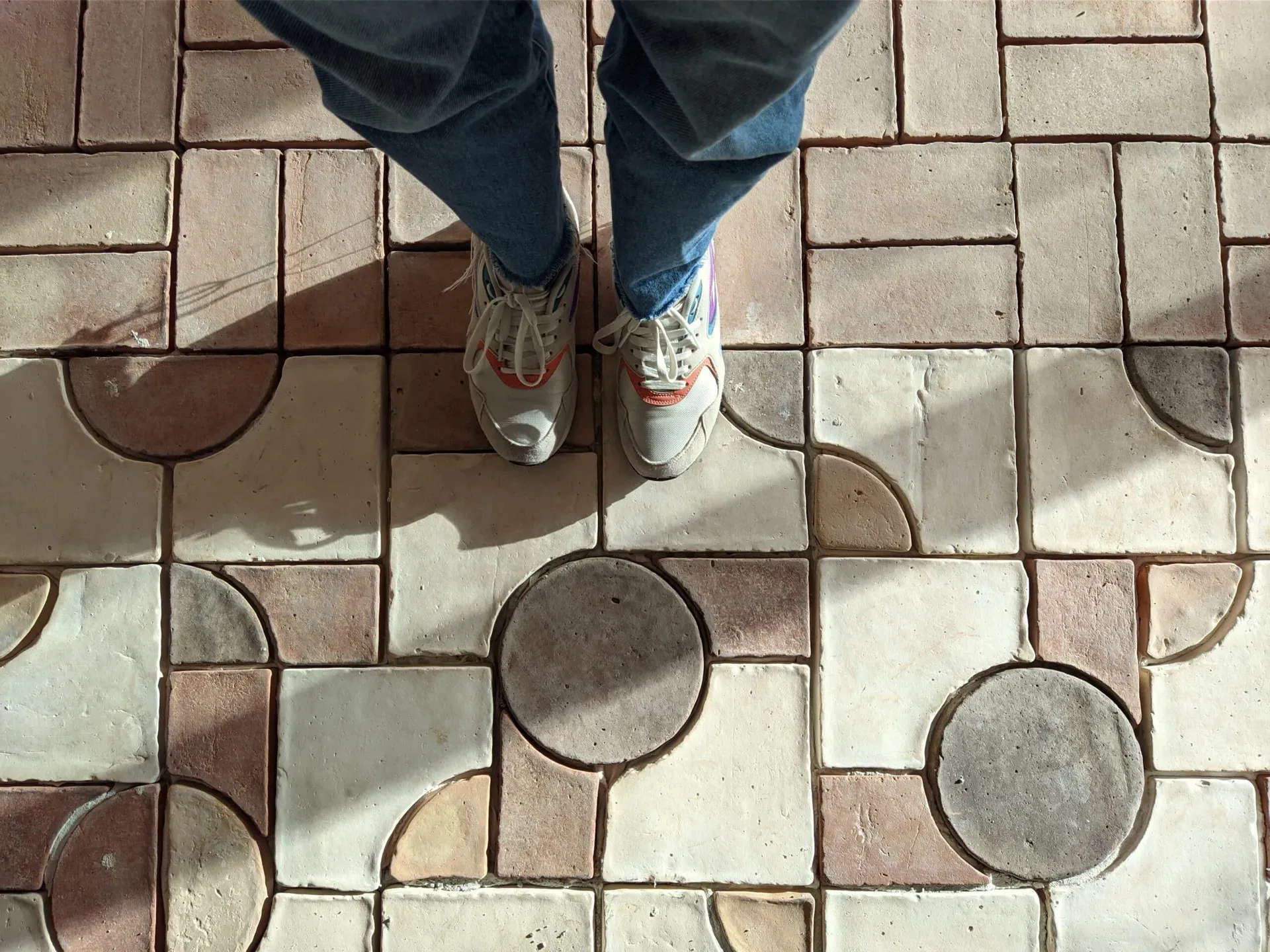 Overhead perspective of feet on clay floor, human connection with the noble material